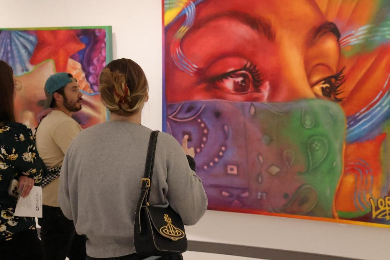 Community members view the large mural artwork by Lone Star College-University Park graduate and professional artist Taylor Barnes at the “Taylord: Anemoia” exhibit in the Visual & Performing Arts building on campus